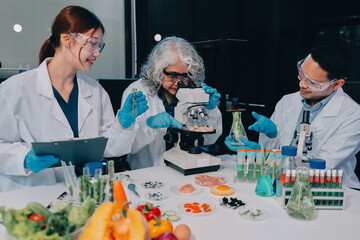 Team Asian scientists in a lab conducting food research using a microscope and lab equipment,...