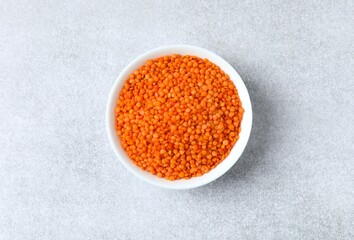 Red lentils in a bowl on a gray background