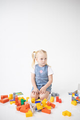 Educational Toys: The Child Develops Motor Skills With The Help Of Colorful Cubes on a white background. The girl is playing with cubes