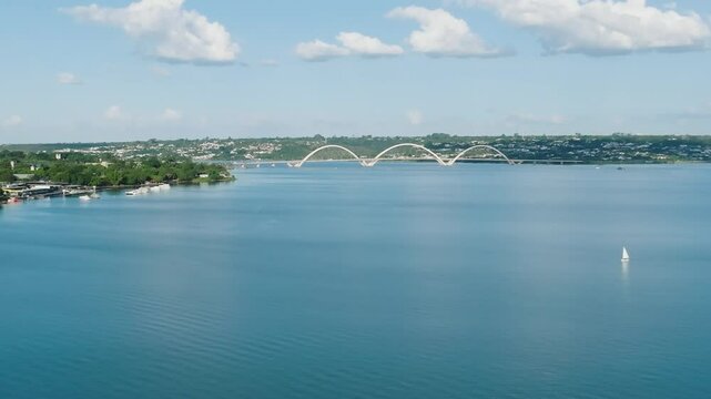 Aerial view of The Juscelino Kubitschek Bridge over the blue water of Paranoa Lake on a sunny day