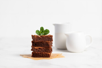 Pieces of chocolate brownies on a light background. Delicious and sweet homemade pastries for breakfast. Vegetarian dessert.
