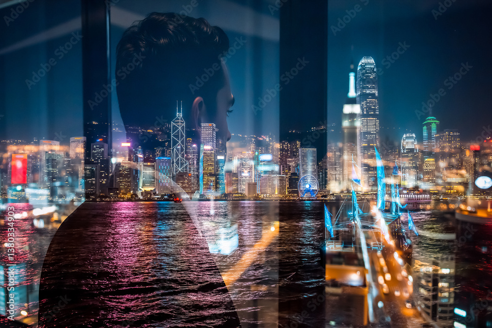 Poster a double exposure image showing a person looking out at the vibrant hong kong cityscape at night. th