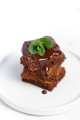 Pieces of chocolate brownies on a light background. Delicious and sweet homemade pastries for breakfast. Vegetarian dessert.
