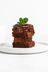 Pieces of chocolate brownies on a light background. Delicious and sweet homemade pastries for breakfast. Vegetarian dessert.
