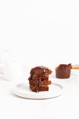 Pieces of chocolate brownies on a light background. Delicious and sweet homemade pastries for breakfast. Vegetarian dessert.
