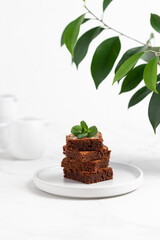 Pieces of chocolate brownies on a light background. Delicious and sweet homemade pastries for...