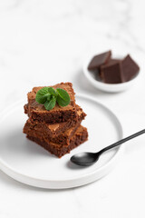 Pieces of chocolate brownies on a light background. Delicious and sweet homemade pastries for breakfast. Vegetarian dessert.
