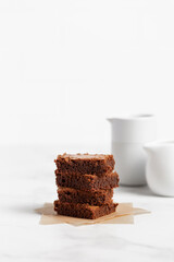 Pieces of chocolate brownies on a light background. Delicious and sweet homemade pastries for breakfast. Vegetarian dessert.
