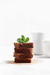 Pieces of chocolate brownies on a light background. Delicious and sweet homemade pastries for breakfast. Vegetarian dessert.
