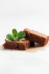 Pieces of chocolate brownies on a light background. Delicious and sweet homemade pastries for breakfast. Vegetarian dessert.
