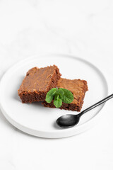 Pieces of chocolate brownies on a light background. Delicious and sweet homemade pastries for breakfast. Vegetarian dessert.
