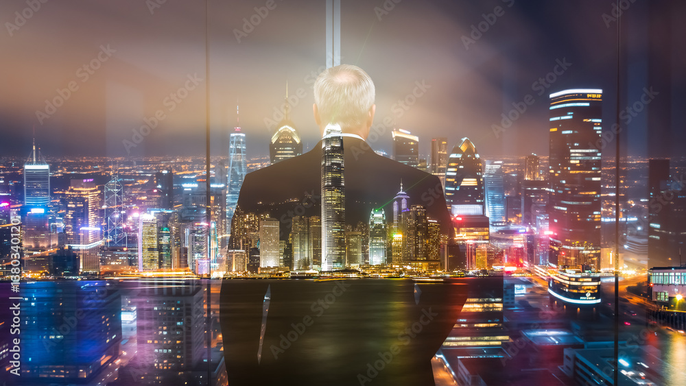Poster a businessman in a suit gazes at the hong kong skyline at night. a double exposure creates a layered