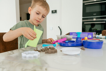 Boy Creating Sand Art on a Table at Home