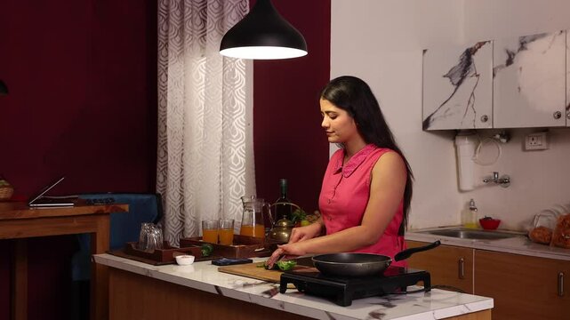 A woman cooking while enjoying her music