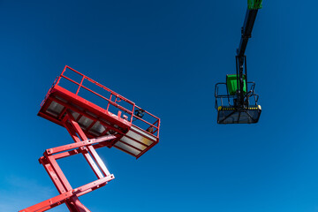 colorful and new industrial lift machinery platforms raised in the air, lifting equipment for...
