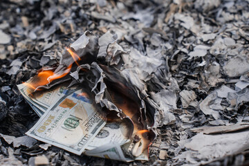 Burning US Dollar Bills on Ashes Representing Financial Loss and Waste