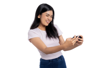 Happy young Asian woman playing mobile game with excitement, smiling and cheering while holding smartphone, isolated on transparent background