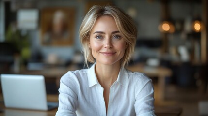 Portrait of a smiling beautiful blonde woman, 30-35 years old, employee in a white blouse, in the office