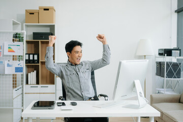 Confident business expert attractive smiling young man typing laptop and holding digital tablet on desk