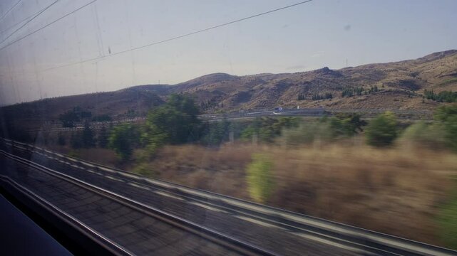 Real time footage of landscape outside of train window. View from inside train compartment