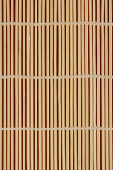 A close-up, flat-lay image of a traditional bamboo sushi rolling mat, also known as a makisu