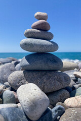 summer background. a beautiful pyramid of stones built on the seashore on a sunny day