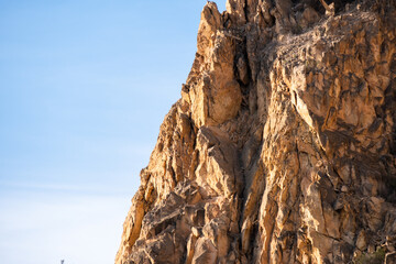 Majestic rocky cliff against clear blue sky in natural sunlight