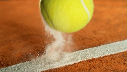 Freeze Motion Detail Shot of Tennis Ball Hitting a Clay Court