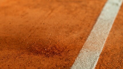 Freeze Motion Detail Shot of Tennis Ball Hitting a Clay Court