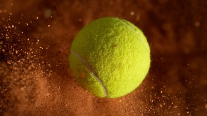 Freeze Motion Detail Shot of Flying Tennis Ball with Clay Explosion © Lukas Gojda