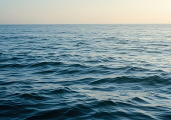 Obraz premium A serene view of the ocean with gentle waves under a soft sky at golden hour light reflecting softly