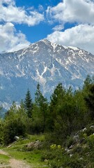 Obraz premium Vertical photo of Mount Tahtali on the Lycian Way, Turkey, with a hiking trail leading towards the peak. Ideal for trekking, travel, mountain landscapes, outdoor adventure, and nature exploration.