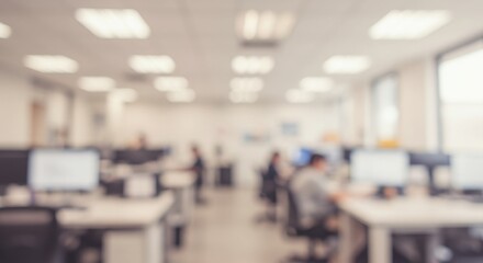 Fototapeta premium Blurred office space with desks computers and people working in a modern bright environment indoors