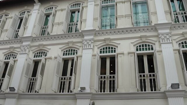 Front view of traditional vintage Singapore shop house exterior with arched windows and open antique wooden