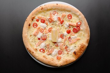 Delicious Pizza Topped with Salmon, Tomatoes, and Lemon