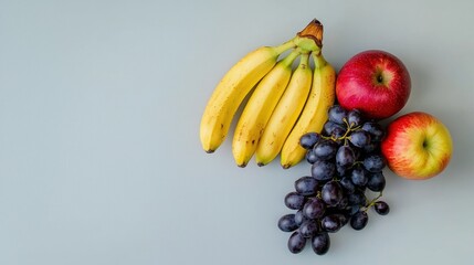 Fresh fruits like apples, bananas, and grapes on a white background.