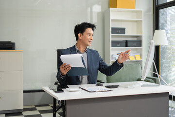 Mature businessman calculate and analyzing graph document financial with report and laptop in office.