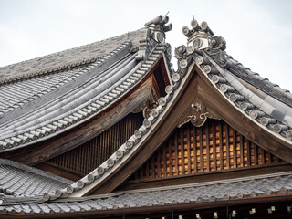 Architecture Japan. Roofs of traditional buildings in Kyoto. Roofs of houses are decorated with hieroglyphs. Architecture in national Japanese style. Rooftops of Japanese buildings under morning sky