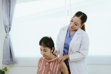 Obraz premium A female physician provides care and assistance to elderly patients during medical consultations, focusing on physical therapy and recovery from conditions such as arthritis.