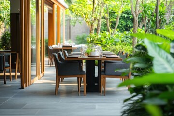 Fototapeta premium A serene outdoor dining setting bathed in soft sunlight, inviting guests to savor a tranquil meal amidst lush greenery and warm, natural tones.