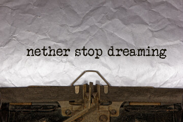 nether stop dreaming close up of a phrase being typed and centered on a sheet of paper on an old...