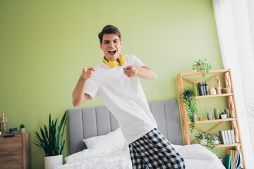 Young man in casual sleepwear enjoying a relaxed morning at home in a modern and cozy bedroom