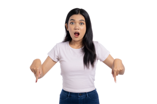 Surprised young Asian woman pointing down with both hands, isolated on transparent background