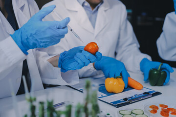 Team Asian scientists in a lab conducting food research using a microscope and lab equipment,...