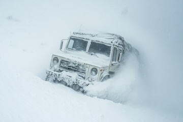 An extreme blizzard surrounds an overlander, the vehicle nearly buried in snow on a mountain pass
