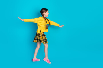 Charming adorable Girl in Stylish Yellow Attire Standing Confidently with a Bright Blue Background Celebrating Joyful Youthful Energy