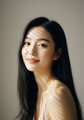 Naklejka premium Portrait of a Smiling Asian Woman with Long Black Hair, Sunlit Face, Light and Shadow.