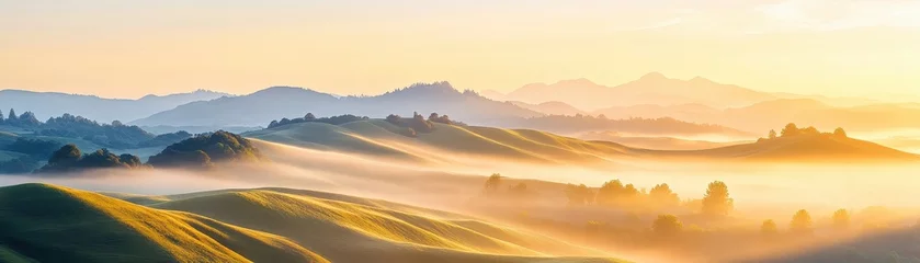 Papier peint photo intissé Stunning Misty Mountain Landscape at Sunset with Glowing Golden Sky and Rolling Hills