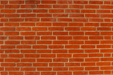 Texture of a red brick wall with even rows of bricks and light mortar between them. Ideal for backgrounds, interior design or architectural projects. Laconic and natural look.