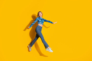 Fototapeta na wymiar Trendy young woman in stylish casual outfit posing joyfully against a vibrant yellow background